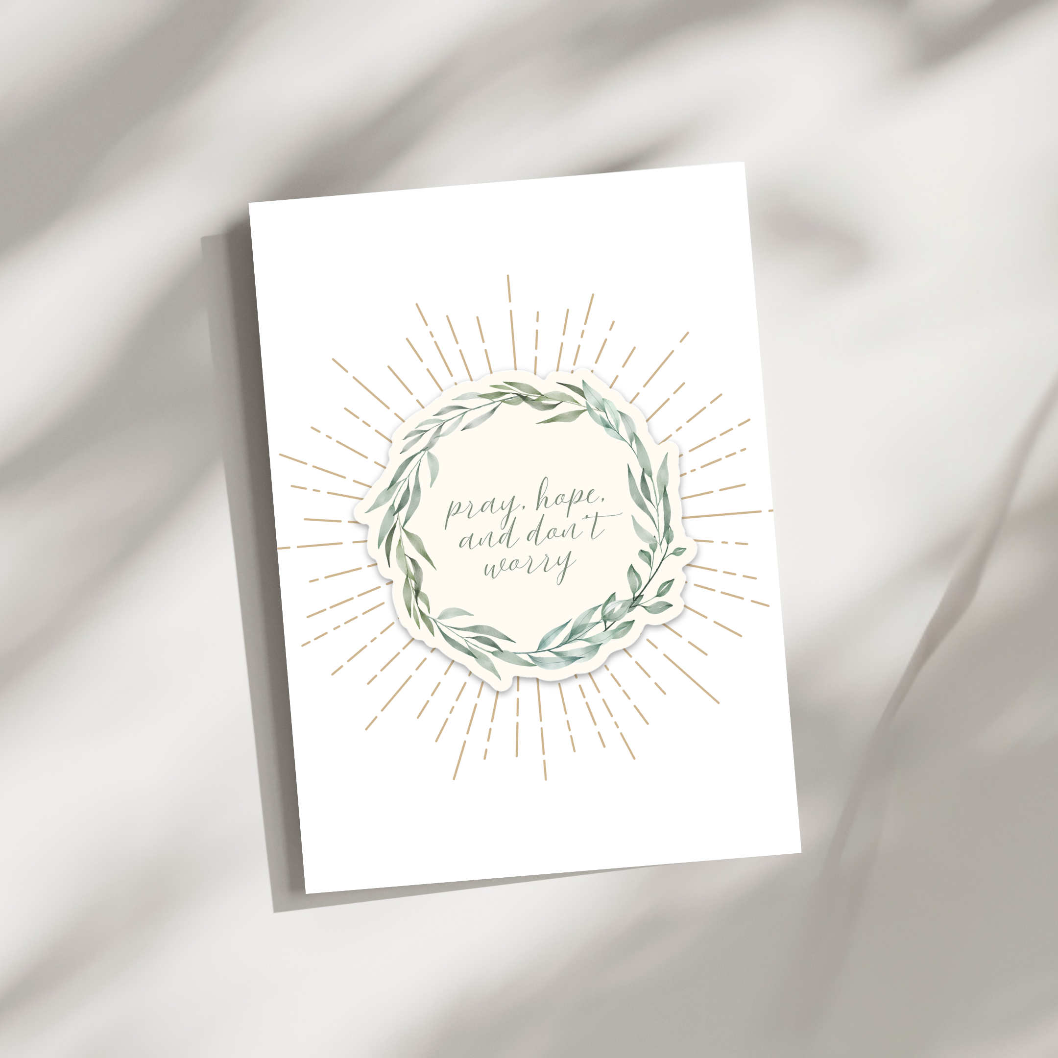 Greeting card with floral wreath and text 'pray, hope, and don't worry' on a white background